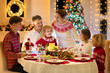 © famveldman - Family with kids having Christmas dinner at tree