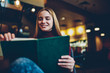 © BullRun - Young beautiful smiling talented female student reading interesting literature while sitting in comfortable coffee shop.Charming cheerful blonde female person enjoying recreation with book in cafe