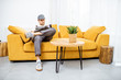 © rh2010 - Handyman in workwear sitting on the yellow couch while resting after the work