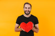 © Drobot Dean - Image of happy man wearing t-shirt smiling and holding red paper heart