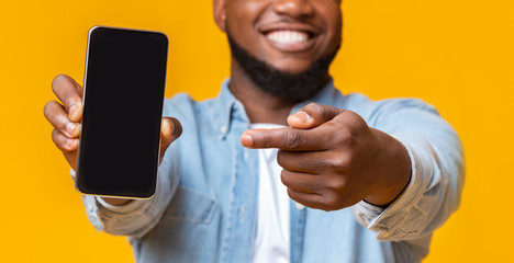 Poster - Man holding smartphone with black screen and pointing on it