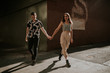© Alina Schessler - Young urban couple holding hands on a sunny afternoon walk
