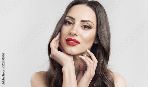 Fotomural Portrait of brown hair cute woman with red lips touching her soft skin isolated