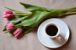 red tulips and cup of coffee on wooden table