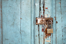 Rusty Padlock On Old Blue Colored Wood Door