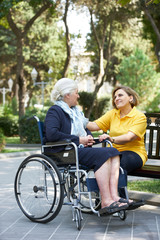 Careful caregiver taking care of the patient, outdoors.