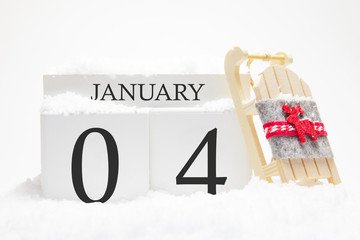 Wooden calendar for January, 4 th day of the winter month. The symbols of winter are snow and sleigh. Concept of holidays, vacation and winter fun.