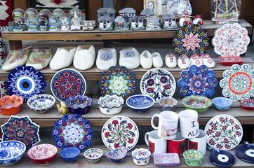 Wall Mural - Albanian souvenirs - traditional woolen felt shoes and handmade painted bowls and plates