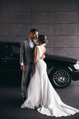 Wall Mural - wedding photo next to a black car.beautiful couple wedding photo