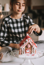 Girl Decorating A Gingerbread House