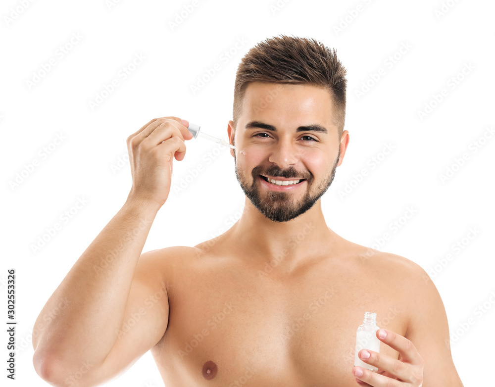 Handsome young man with cosmetic product on white background