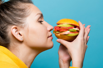 girl is looking forward to the taste of a diet fruit burger made from fresh fruits