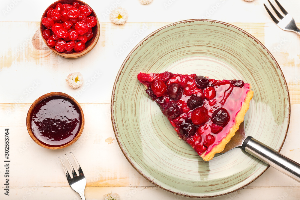 Plate with piece of tasty cherry pie on table