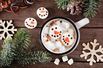 Wall Mural - Hot chocolate with snowman marshmallows. Top view table scene with Christmas decor against a dark wood background.