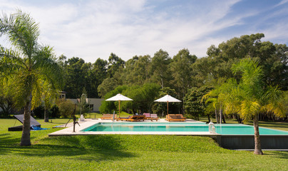 Beautiful view of a swimming pool in a sunny day. Gardens of a typical countryside lodging (estancia), perfect for a romantic getaway next to the city. Colon, Entre Rios, Argentina