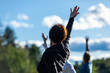 © Valmedia - Selective focus of adult woman putting her arm up to the sky along with other people while participating in yoga session