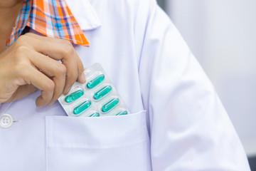 Pharmacist hand holding pack of antibiotic capsule pills, Pharmacist working in pharmacy shop or chemist shop with medication drugstore.