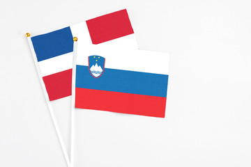 Slovenia and Dominican Republic stick flags on white background. High quality fabric, miniature national flag. Peaceful global concept.White floor for copy space.