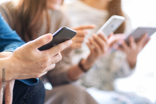 Fotomural Group of people using and looking at mobile phone and tablet pc while sitting to