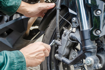 Young man hand are repair and check motorbike engine. Man's hobby concept