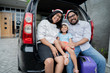 © Odua Images - family with suitcase sitting on car trunk ready for christmas holiday