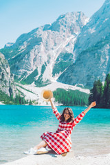 Wall Mural - woman sitting on the beach of mountain lake summer season