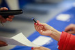 © MoiraM - Shallow depth of field (selective focus) image with the hand of a woman handing a stamp used in the first round of a presidential election, in Bucharest, Romania.