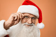 © serhiibobyk - Portrait of senior kind Santa Claus holding hand on glasses