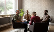 © JonoErasmus - Casual seated diverse business meeting in modern open workspace with large windows and sunlight shining in