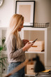 © JustLife - Young businesswoman in office. Beautiful woman drinking coffee and typing message.