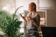 © JustLife - Young businesswoman in office. Beautiful woman drinking coffee and typing message.