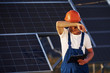 © standret - Feels tired. Male worker in blue uniform outdoors with solar batteries at sunny day
