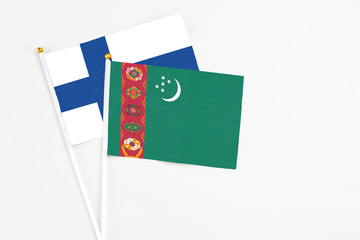 Turkmenistan and Finland stick flags on white background. High quality fabric, miniature national flag. Peaceful global concept.White floor for copy space.