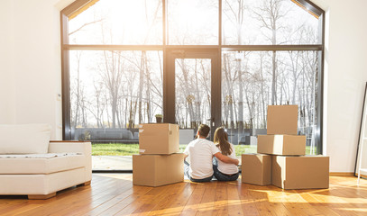 Wall Mural - young couple moves to a new home. the family carries boxes of things after buying a home.