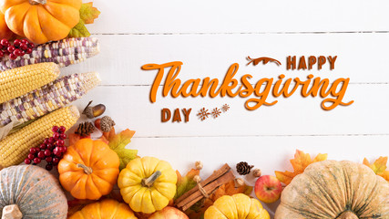 Wall Mural - top view of autumn maple leaves with pumpkin and red berries on white wooden background. thanksgivin