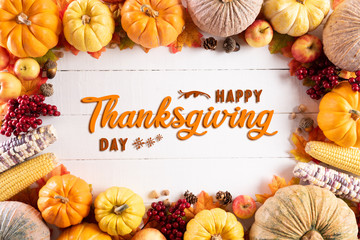 Wall Mural - top view of autumn maple leaves with pumpkin and red berries on white wooden background. thanksgivin