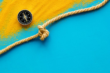 Wall Mural - Goal achievement concept. Compass near rope with knot on blue background top view copy space