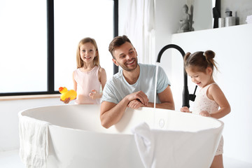 Young father with little daughters in bathroom