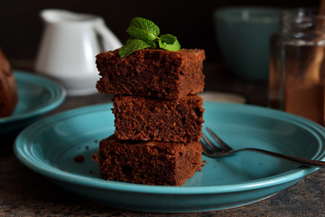 Wall Mural - Chocolate brownie - a classic American dessert in a blue plate on a concrete background.