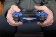 © Chris DoAl - Boy hands holding a blue gamepad playing video games
