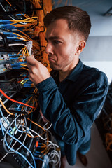Wall Mural - Close up view of funny man with internet wires in server room