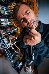 Wall Mural - Close up view of funny man with internet wires in server room