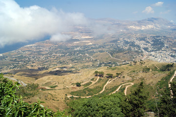 Wall Mural - Panoramic view from  the Italian hill top town of Erice on the island of Sicily.  Broad sweeping views over the countryside towards the Mediterranean sea. An atmospheric summers day.