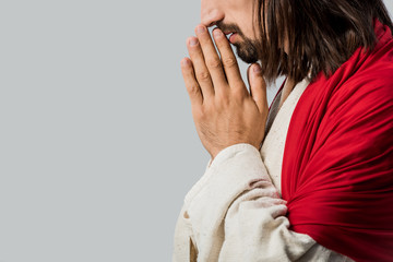 Wall Mural - side view of bearded man praying isolated on grey