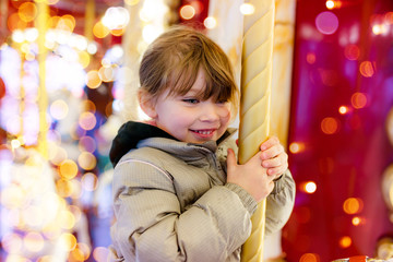 Sticker - pretty young girl taking a ride in a carousel at christmas