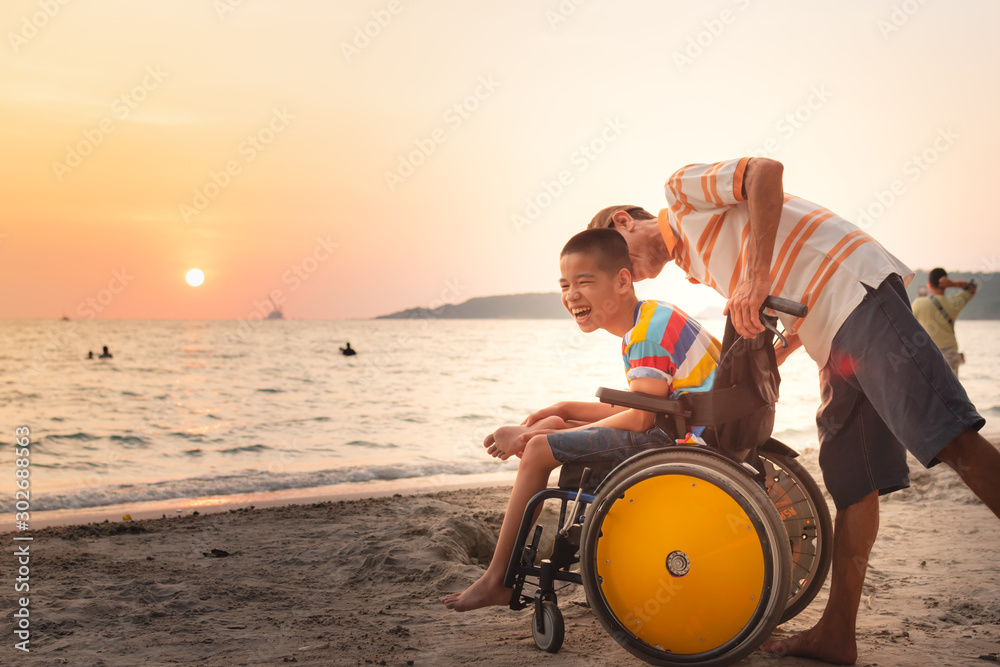 Asian special child on wheelchair is happily on the beach with father,Dad and son spend holiday to travel and learning about nature around the sea,Life in the education age,Happy disabled kid concept. - obrazy, fototapety, plakaty 