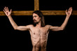 shirtless man crucified on wooden cross isolated on black