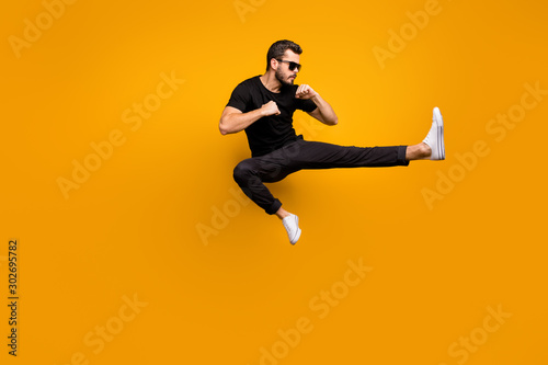Full length photo of handsome guy jumping high practicing self defense kicking c Poster Mural XXL