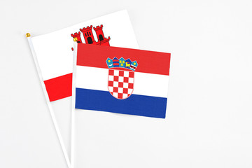 Croatia and Gibraltar stick flags on white background. High quality fabric, miniature national flag. Peaceful global concept.White floor for copy space.