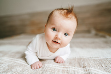 cute baby ginger hair close up crawling on bed smiling adorable kid portrait family lifestyle 3 mont